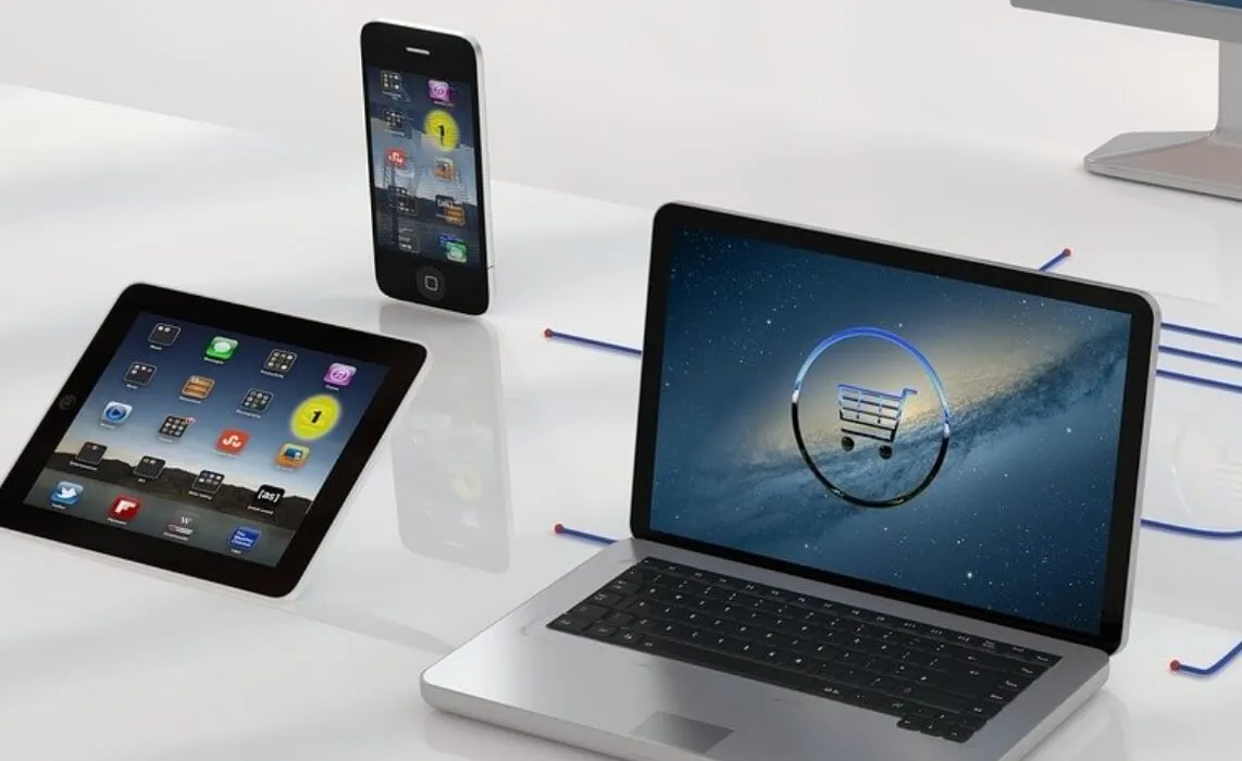 半透明のテーブルの上にスマートフォン・タブレット・パソコンが置いてあります
